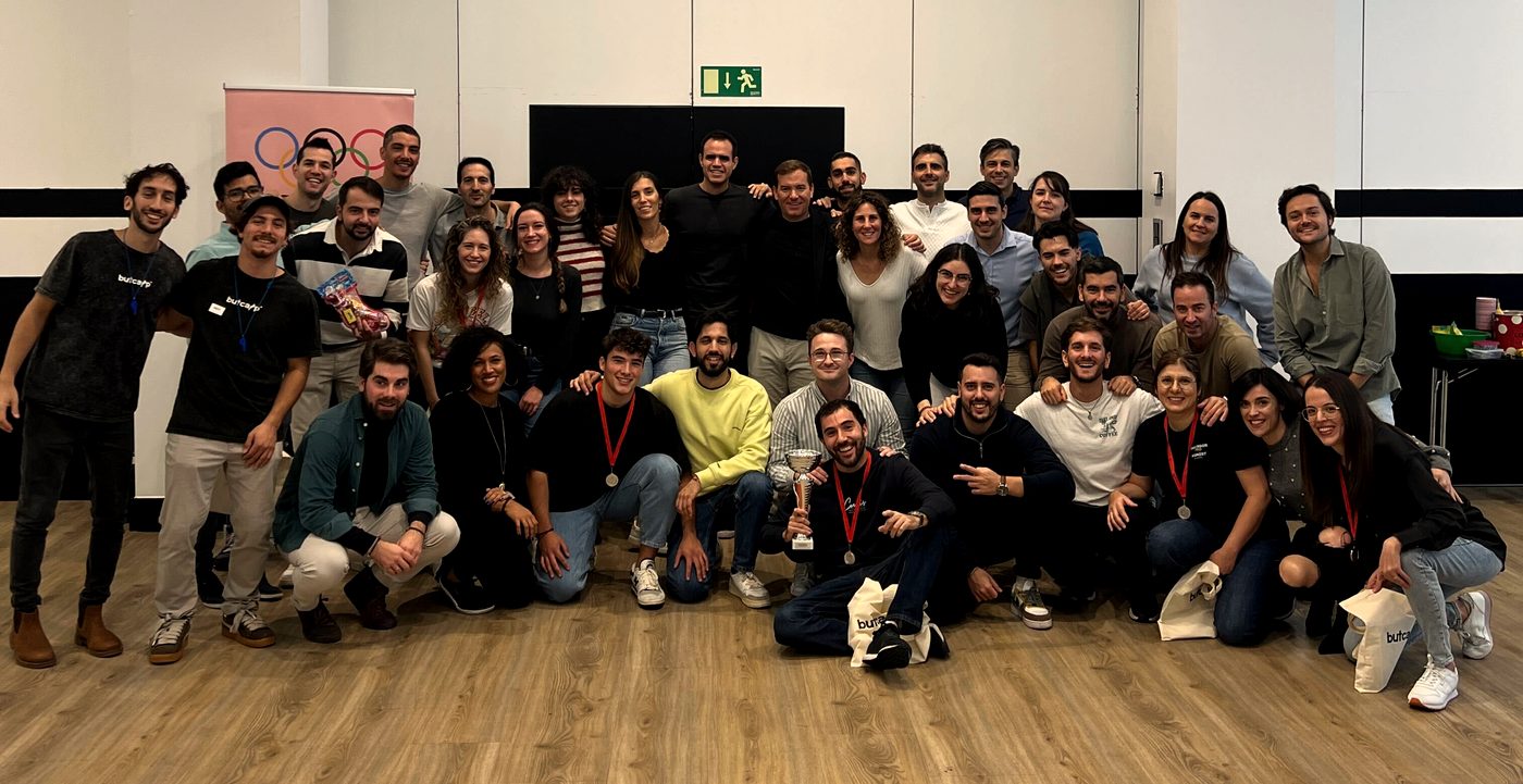 Foto de grupo de un equipo en un evento, con un trofeo